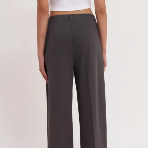 Grå kostymbyxor med vida ben - Snygga grå kostymbyxor med hög midja och vida ben. Byxorna har en knapp och dragkedja framtill. Storlek: 40, långa på mig för referens så är jag 164cm, aldrig använda mer än när jag testade dom och på bilden.                                           Ord.pris: 300kr