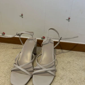 Beige klackar - Snygga beige sandaler från XIT med smala remmar och en stabil klack. Perfekta för sommarens alla tillfällen. Justerbar rem runt ankeln för bästa passform.