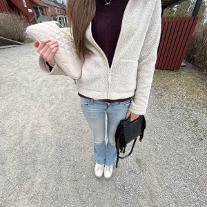 Vit teddyjacka med dragkedja - Mysig vit teddyjacka med dragkedja framtill. Perfekt för kyliga dagar med sin fluffiga och varma design. Jackan har en enkel och stilren look som passar till allt. Har en liten defekt på dragskedjan men påverkar ej varan och syns ej ❤️