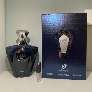 Afnan Turathi Black Eau de Parfum - Upptäck Afnan Turathi Black, en elegant Eau de Parfum. Doften bjuder på en citrusfrisk öppning med inslag av mysk, trä och fräscha noter. Den har även varma noter av amber, pudrighet och patchouli som ger en kryddig och djup karaktär. En toppen parfym för en daglig användning. Säljs i 1-5ml 