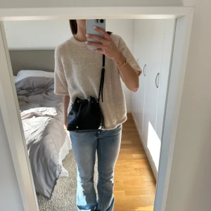 Svart axelväska  - Svart axelrems väska från H&M med guldiga detaljer.