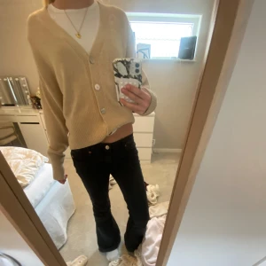 Beige kofta med knappar - Säljer en mysig beige kofta med v-ringning och knappar, v-ringad. Storlek XS!