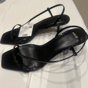 Svarta sandaler från MNG - Eleganta helt oanvända svarta sandaler från MNG med smala remmar och fyrkantig tå. Perfekta för en stilren look. Säljer då de var för små för mig.