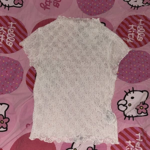 Vit spetsblus - Säljer en söt vit spetsblus med korta ärmar och hög hals. Perfekt för en romantisk look eller en somrig dag. Blusen har ett vackert spetsmönster som ger en elegant touch. Pris kan diskuteras💗