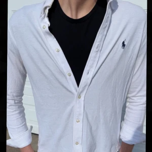 Ralph lauren skjorta - Vit Ralph lauren skjorta med blå Ralph lauren logga på bröstet. Storlek: Mindre S. Eftertraktad nu inför sommaren/våren. Skick 9/10. Kontakta om minsta intresse!