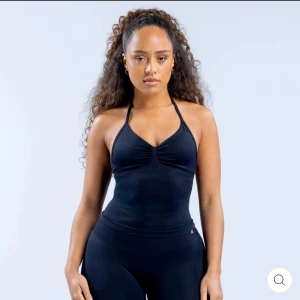 Svart halterneck linnetopp från DFYNE - Snygg svart halterneck linnetopp från DFYNE. Toppen har en åtsittande passform med en stilren design och öppen rygg. Perfekt för både träning och vardag.