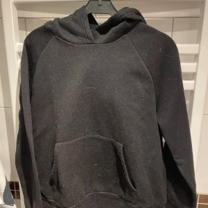 Svart hoodie med tryck på ryggen - Fin och skön hoodie i fleece material med fint tryck på ryggen storlek Small