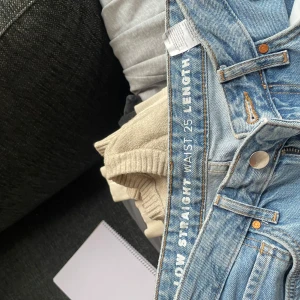 Blå jeans med rak passform - Säljer ett par klassiska blå jeans med rak passform. De har en knappgylf och är i en ljusblå tvätt. Perfekta för en avslappnad stil. W25 L32