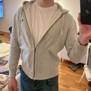Grå zip-hoodie från Ralph Lauren - Säljer en grå zip hoodie från Ralph Lauren med dragkedja och huva. Sparsamt använd, säljer då den är för liten. Nypris ca 2000