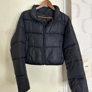 Svart croppad pufferjacka från ASOS DESIGN - Säljer en svart croppad pufferjacka från ASOS DESIGN. Jackan har en dragkedja framtill och långa ärmar 🖤