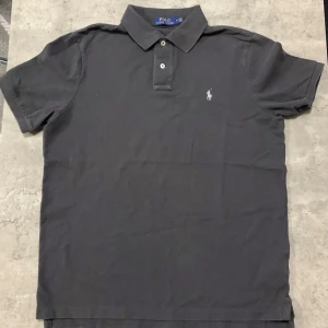 Grå pikétröja från Ralph Lauren - Säljer min Ralph Lauren pike då jag inte har användning för den längre! Fint och klassiskt, grå färg med vit logga, den är classic fit. Såklart är den äkta, vid frågor eller likande så finns jag att skriva till😁