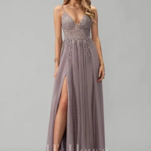 Långklänning i lila med spetsdetaljer - Elegant långklänning i lila med v-ringad urringning och smala axelband. Klänningen har vackra spetsdetaljer på överdelen och en hög slits framtill. Enbart använd en gång så den är verkligen som ny!💕 nypris är 2271kr 