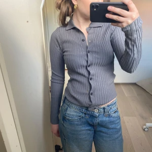 Grå ribbad kofta - Säljer en stilren grå ribbad kofta med knappar framtill. Koftan har en klassisk krage och långa ärmar. Koftan är från Zara som är köpt för 400 och aldrig annvänts. Kontakta för fler bilder!!🤗🤗
