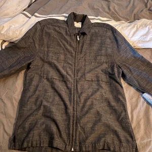 Grå overshirt med dragkedja - Snygg grå overshirt från Visual Clothing Project med dragkedja framtill. Jackan har långa ärmar och en klassisk krage. Perfekt för lager-på-lager stil. Priset går att diskutera! :)) 