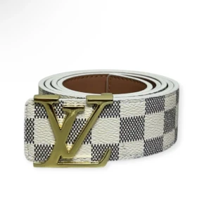 Louis Vuitton rutig bälte med LV-spänne - Snyggt bälte från Louis Vuitton med klassiskt rutigt mönster i vitt och grått. Bältet har ett stort, guldigt LV-spänne som verkligen sticker ut. Tillverkat i skinn med exklusiv känsla och passar perfekt till jeans eller kostymbyxor.