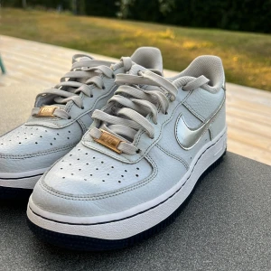 Nike Air Force 1 Low Silver/White - Säljer ett par Air force1. Skorna är i ett mycket bra skick, knappast använda. Den har bara en liten svart fläck på framsidan. Det är en sko som man får många komplimanger, och kommer göra dina vänner avundsjuka. Dem kommer och med 4 extra AF1 tags! 100% äkta, köpta från nike hemsidan! Storlek 36.