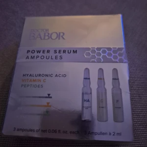 Doctor Babor Power Serum Ampoules - Power Serum Ampoules från Doctor Babor med hyaluronsyra, vitamin C och peptider. Förpackningen innehåller tre genomskinliga ampuller à 2 ml, perfekta för att boosta huden med fukt och lyster. Snygg silverfärgad kartong med modern design.