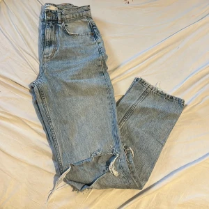 Ginatricot blåa jeans  - Jag säljer ett par ljusblåa jeans med hål på knäna. Modellen är hög till mellanhög midja och raka ben. Säljer pga fel storlek. Hör av er vid frågor och funderingar 💕