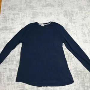 Mörkblå långärmad tröja från Zara Boys - Snygg mörkblå långärmad tröja från Zara Boys med rund hals och ribbad detalj vid halsringningen. Tröjan är tillverkad i mjuk bomull och har en enkel, clean look som funkar till jeans eller chinos. Perfekt för dig som gillar stilrena basplagg.