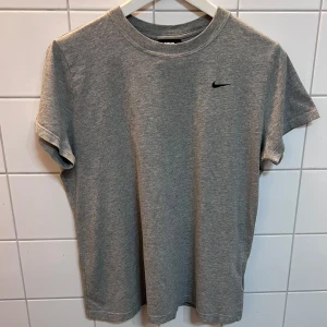 Nike Grå T-Shirt - 100 % Bomull. Broderad logga. Nyskick.