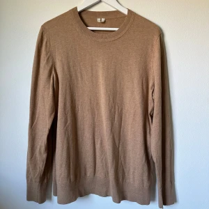 Beige stickad tröja från Arket - Snygg beige stickad tröja från Arket i storlek M. Tillverkad i en mjuk mix av bomull och kashmir som känns skön mot huden. Tröjan har rund hals och långa ärmar, perfekt för lager-på-lager under hösten och vintern. 1A12