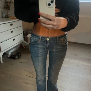 Lågmidjade bootcut jeans från Mavi - Säljer ett par blå mavi jeans med låg midja och bootcut passform. Jeansen har klassiska fem fickor, snygga slitningar och ljusare tvätt på låren.