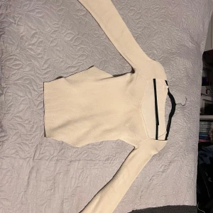 Beige ribbad långärmad tröja - Säljer en stilren beige långärmad tröja med ribbad struktur. Tröjan har en rund hals och är figurnära i modellen, perfekt för dig som gillar enkla och snygga basplagg. Materialet känns mjukt och skönt mot huden, och färgen är lätt att matcha med allt.