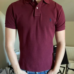 Vinröd Polo Ralph Lauren Piké - Snygg vinröd piké från Polo Ralph Lauren i custom slim fit. Storlek S 