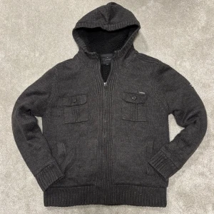 Stickad Cardigan/Kofta med Päls - Säljer denna stickade grå cardigan/kofta med pälsliknande fodring i hela koftan! Cardiganen är i bra skick, inga defekter! Size L passar även M. Modellen på bilden 182cm lång ish. Skriv vid funderingar!