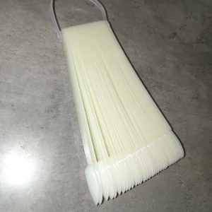 Nagel display - Säljer ett set med vita nageltips på ring, perfekt för att visa upp olika nagellack eller nail art. Displayen har en oval form, smidiga att använda för swatches eller övning. Ringen håller ihop alla tips så de är lätta att bläddra igenom.