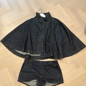 Mörkblå jeansshorts från Zara - Cape och shorts i ett set från zara🥰 aldrig använt! Capen är i s ocv shortsen i xs