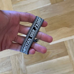 Christian Dior J'Adior armband svart/vitt - Snyggt vävt armband från Christian Dior. Har inte någon användning för det och har ändrat stil så passar inte längre. OBS: Kom med bud så kan vi förhandla!
