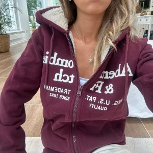 Abercrombie & fitch zip med teddyfoder  - En zip med foder i storlek XS från Abercrombie & fitch. Tröjan kan upplevas större i storlek pga oversized fit. Tröjan bedöms vara i väldigt fint skick. Jag skickar inom 24h. Se liknande zip i min profil. E75
