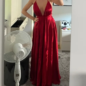 Balklänning  - Säljer min röda balklänning. Den har öppen rygg med resår o långa band. Skriv för mer bilder