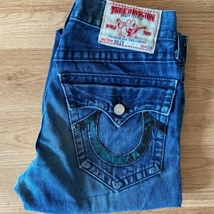 True Religion Jeans Billy - Feta true religion jeans, bootcut / flare, storlek 30 i bra skick men fixad i grenen. 40.5cm midja, 104.5cm längd, 80cm innerben och 25cm ben öppning. 