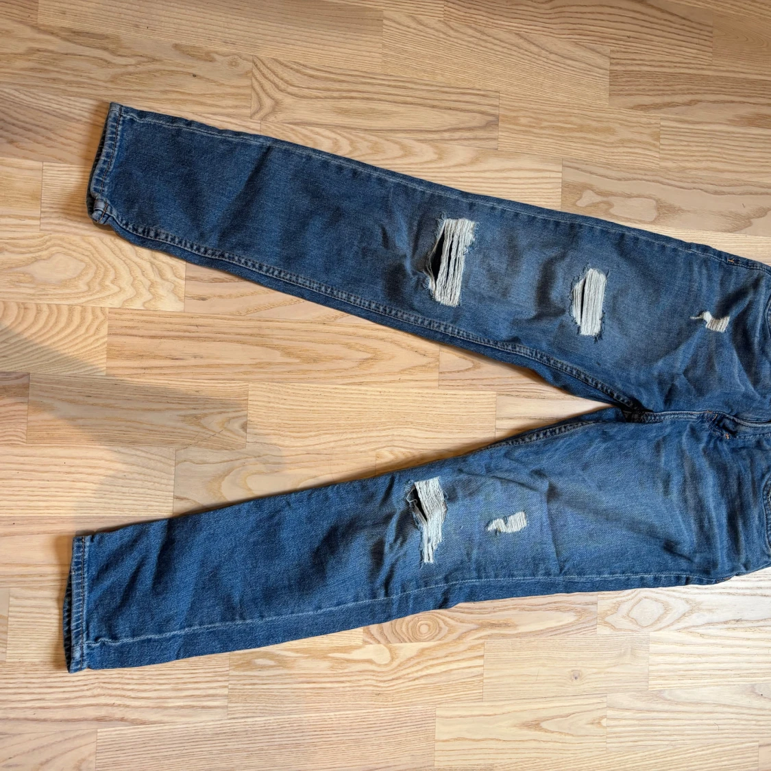 Slim fit blå jeans med slitningar