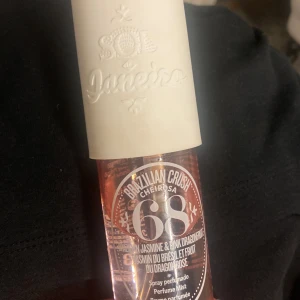 Sol de Janeiro Cheirosa 68 Perfume Mist - Fräsch och tropisk body mist från Sol de Janeiro, Cheirosa 68. Flaskan är cylinderformad i transparent rosa plast med vit kork. Doften har noter av brasiliansk jasmin och pink dragonfruit, perfekt för dig som gillar söta och exotiska dofter.