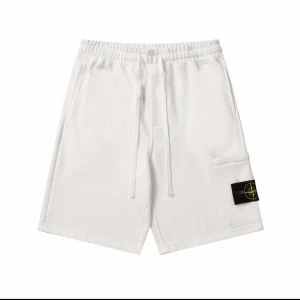 Vita shorts från Stone Island - Snygga vita shorts från Stone Island med klassisk logopatch på benet. De har elastisk midja med snörning och en praktisk ficka på sidan. Perfekta för chill dagar och sommarhäng, riktigt clean look och skön passform.