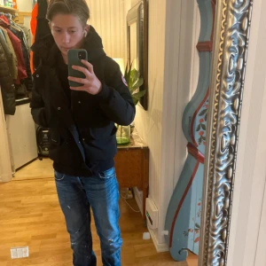 Svart dunjacka från Canada Goose - Tja jag säljer denhär assnygga svarta dunjackan från Canada Goose med huva och klassisk logga på ärmen. Jackan har ett vågig, mjuk och varm insida, dragkedja och praktiska fickor, inklusive en ficka med dragkedja på ärmen. Jackan är i storlek XS-S alltså kommer den passa dig som är från 168-173. Perfekt för kalla dagar och har en snygg, stilren look. Kontakta mig vid minsta lilla fundering🙌 pris kan diskuteras till viss del!