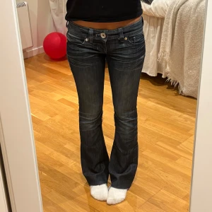Mörkblå bootcut jeans från Guess - Snygga mörkblå bootcut jeans från Guess med låg midja. Storlek W25.