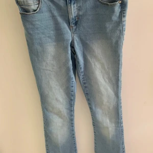 Ljusblå butcut low waist jeans från ONLY, storlek 164 - Säljer ett par ljusblå jeans från ONLY. De är tillverkade i mjukt denimtyg och har en snygg kopparfärgad knapp framtill.