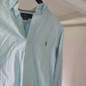 Ljusblå skjorta från Ralph Lauren - säljer denna ljusblåa ralph lauren skjortan perfekt till sommmaren med den ljusa färgen, perfekt passform dessutom. priset är ej hugget i sten, skriv även vid minsta funderingar!!