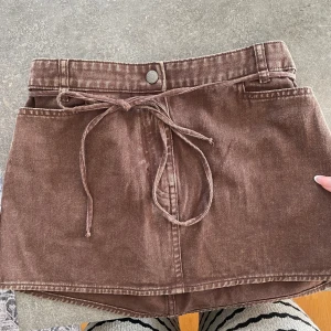 Brun jeanskjol med knyt från Monki - Säljer denna super söt och snygga jeans kjol från Monki, slutsåld. strl 36 med lappar kvar, oanvänd 
