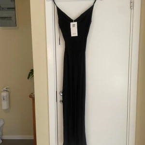 Satinklänning  - Superfin lång satinklänning draperad upptill med liten slits på sidan. Helt ny med prislapp.