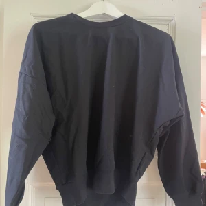 Svart tjocktröja  - Svart oversized tröja som är pösigare upptill och lite tajtare vid midjan. Den är svart trots att den ser lite grå ut på bilden. 