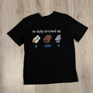 Svart t-shirt med tryck 'im fully bricked up' - Svart t-shirt med vitt och färgglatt tryck framtill. Texten 'im fully bricked up' och bilder på tegel, rör och metall med siffror under. Klassisk passform och rund hals.