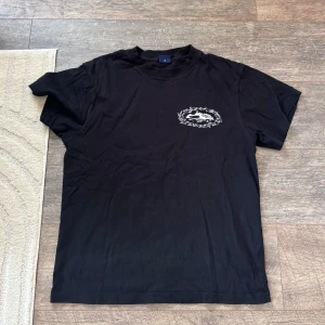 Corteiz T Shirt - Svart t-shirt från Corteiz med vit grafisk tryckdetalj på bröstet och större tryck på ryggen. Klassisk passform och rund halsringning. Perfekt för dig som gillar streetwear och snygga prints. Köpt från CRTZ.RTW, kvitto finns. Cond 9/10. Äkta✅