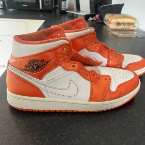 Nike Air Jordan 1 orange och vita - Säljer ett par jordans, vita skosnören följer med(tvättar dom).Dom sitter väldigt bra och är sköna. Säljer dom pågrund av att dom inte kommer till användning något mer.