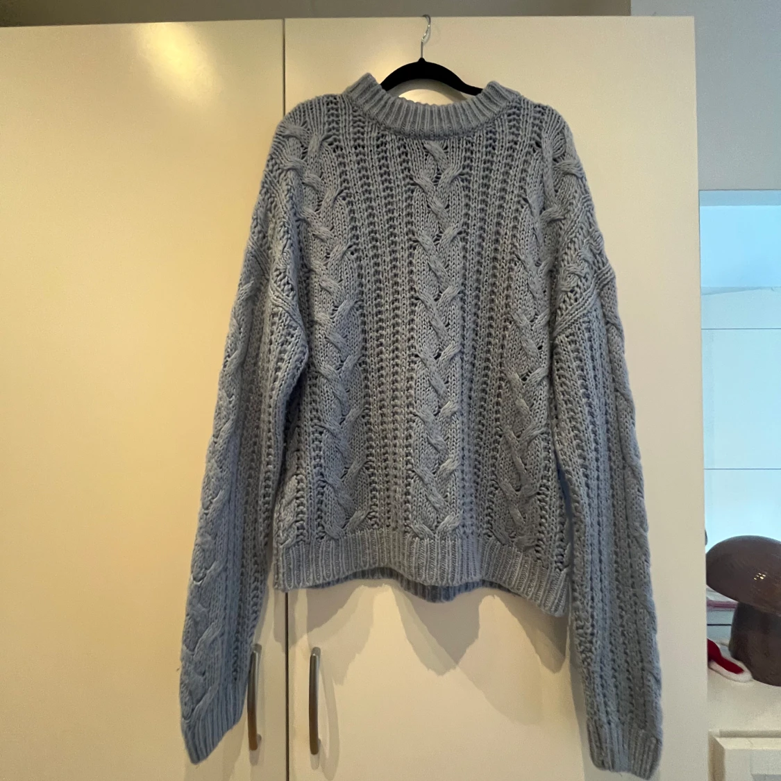 Ljusblå stickad tröja med flätmönster