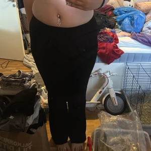 Svarta sammetsbyxor från Amisu - Säljer ett par svarta sammetsbyxor från Amisu i storlek 38. Byxorna har en rak passform och hög midja, vilket ger en snygg siluett. Perfekta för dig som vill ha ett par mjuka och stilrena byxor i garderoben.